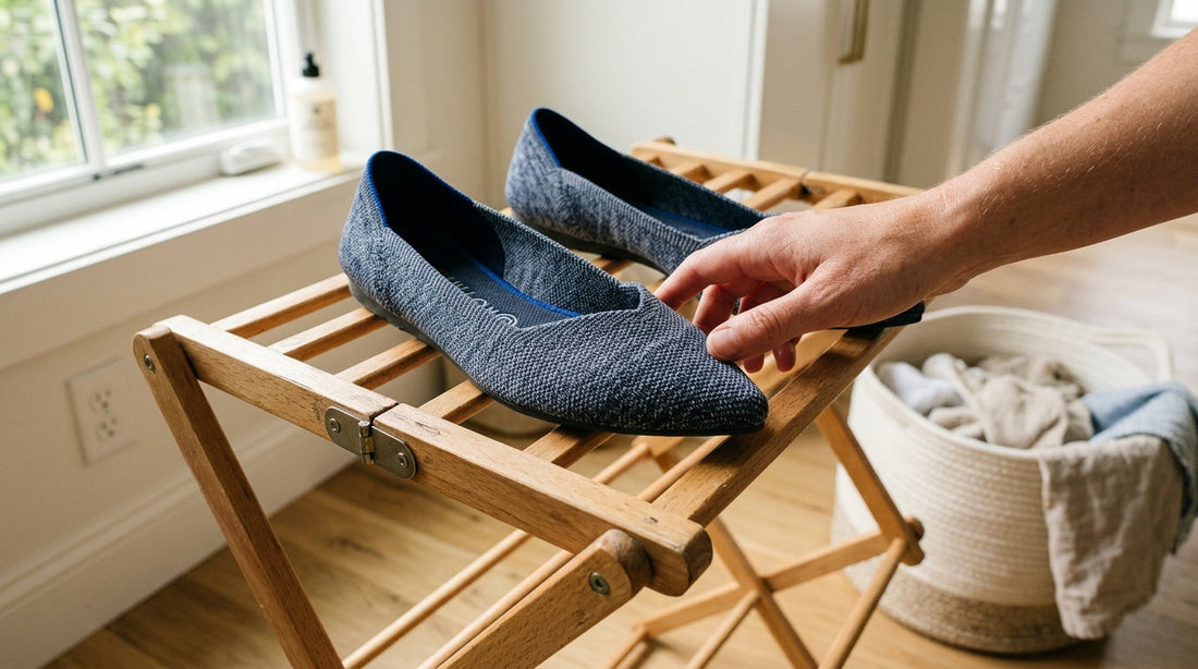 Pointed-toe knit flats sitting on a wooden drying rack in a sunlit laundry room, illustrating why Rothys smell after washing.