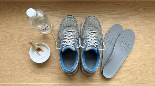A collection of shoe cleaning supplies including sneakers, alcohol, powder, and insoles on a bench.